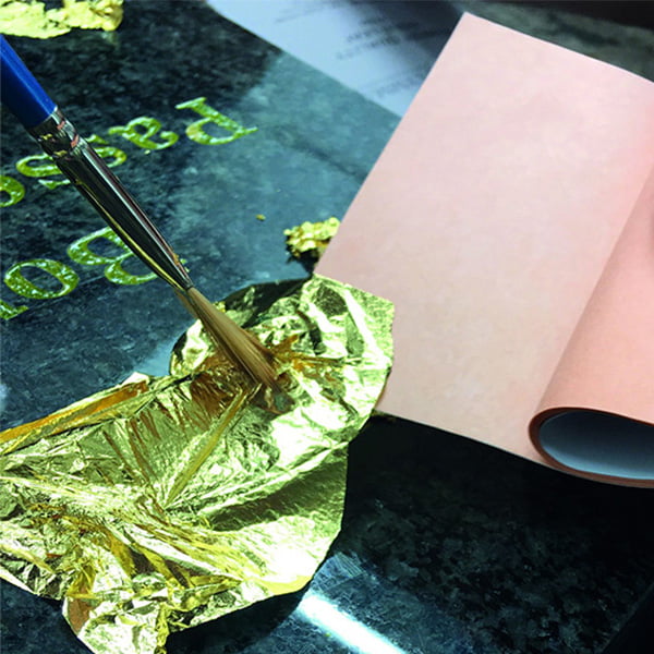 Monumental Sculptor William Todd applying gold foil to a memorial headstone